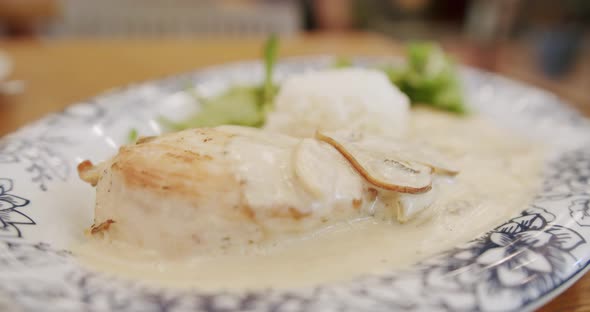 Chicken Fillet with Mushroom Sauce with Rice and Salad Leaves Served on a Plate