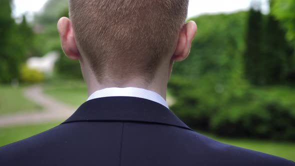 Businessman Groom Young Man Puts on a Jacket in the Park