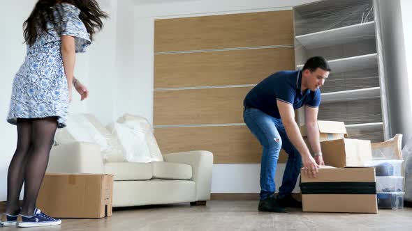 Couple Moving Cardboard Boxes in Their New Flat