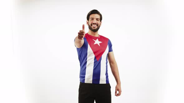 Young Handsome Latin Man Standing Satisfied Because of His Cuban Flag Tshirt and Pointing to It