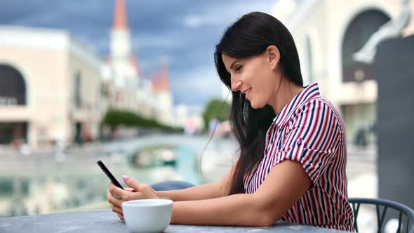 Happy Elegant Female Surfing Internet Use Smartphone at Outdoor Cafeteria