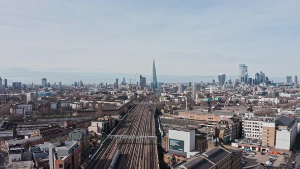 Slider drone shot over national rail train towards London bridge station the Shard city centre