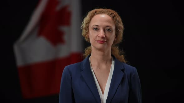 Confident Canadian Female Politician Looking at Camera Smiling with National Flag at Black