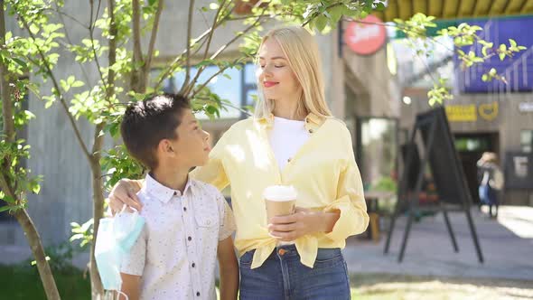 Portrait of Cheerful Woman with Son in Street.