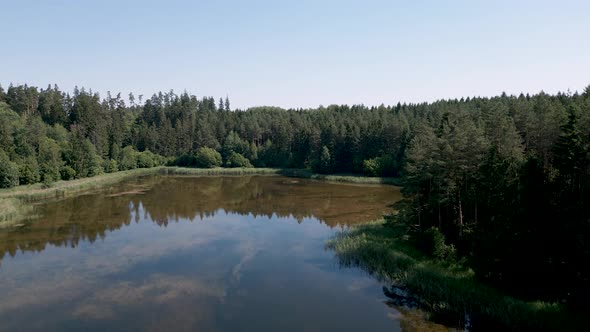 Drone flight aerial bird flyover a tiny lake in Mazury Region in northern and northeastern Poland, f