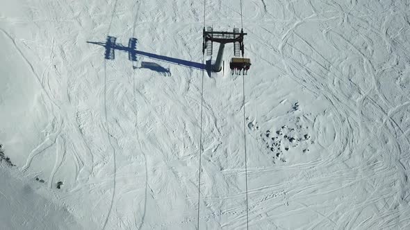 Aerial drone view of ski chair lifts and snow covered mountains in the winter