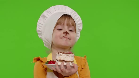 Child Girl Kid Dressed As Professional Cook Chef Showing Eating Tasty Handmade Strawberry Cake