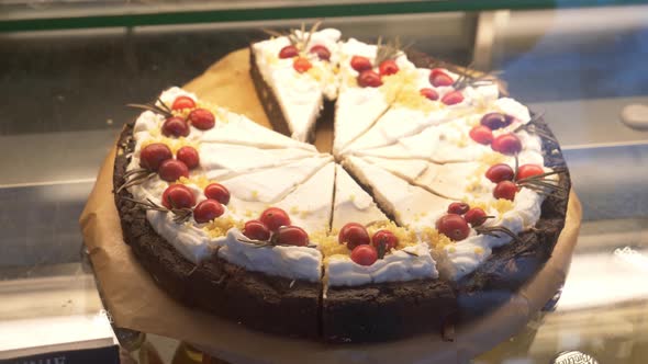 White chocolate cake for sale behind glass in a cafe