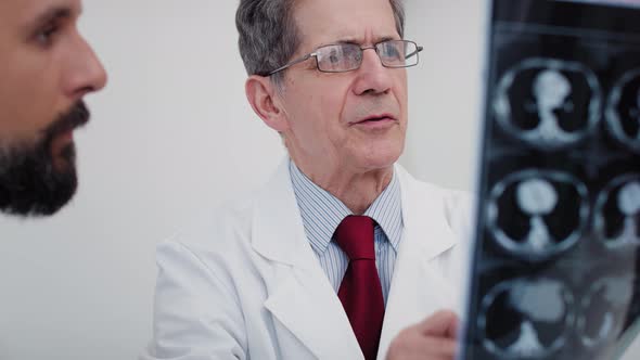 Handheld view of two busy doctors discussing some medical records. Shot with RED helium camera in 8K