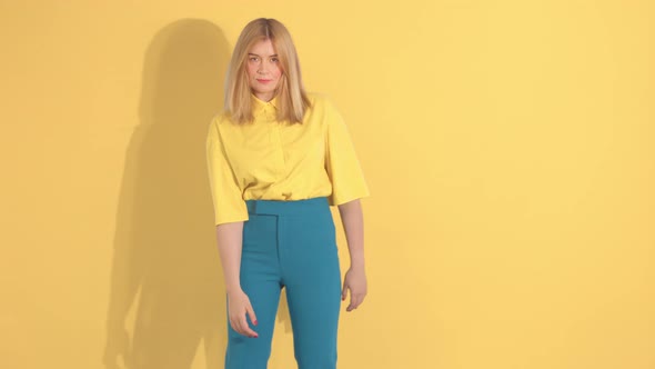 Young Woman in Bright Clothes on Bright Yellow Background in Studio