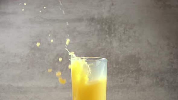 Ice Cubes Fall in Orange Juice