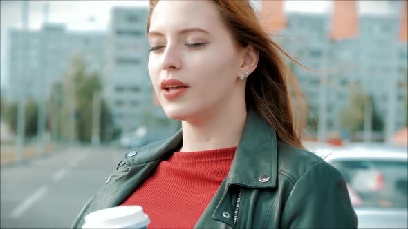 Young Woman Drinking Coffee on the Street, Young Girl With Glasses of a Happy Woman with Long Red