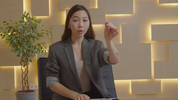 Pretty Asian Woman Psychologist Hypnotizing Patient Using Pendulum Indoors