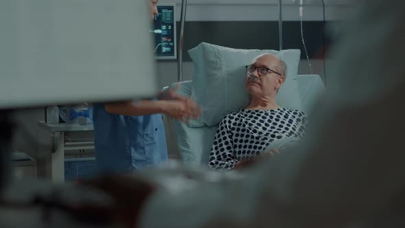 Nurse Checking Oximeter on Sick Patient in Hospital Ward