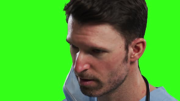 Caucasian male doctor wearing face mask on green screen background