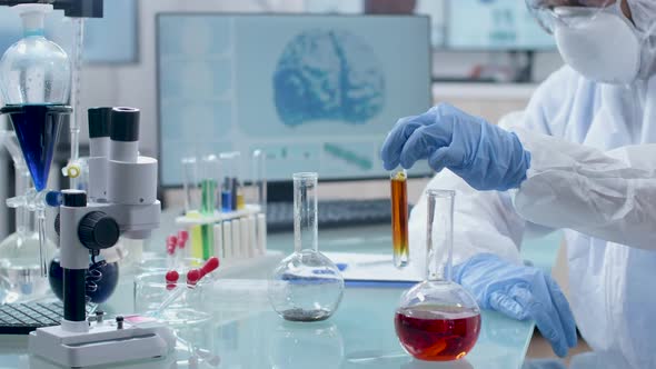 Scientist in Coverall Taking Probes From Colored Liquid