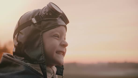 Close-up Shot of Funny Little Boy in Old Pilot Costume with Scarf and Glasses Making Silly Faces