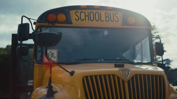 Schoolbus Front Staying on Empty Parking with Yellow Sign Image Children Closeup