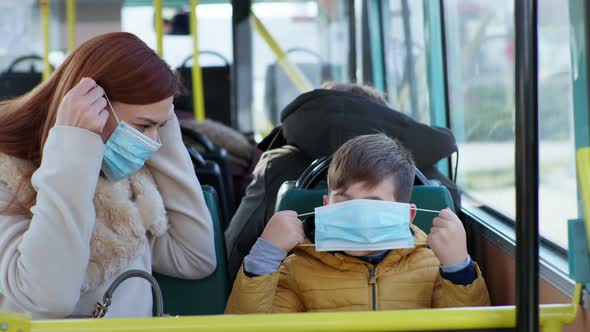 Mother and Male Child Take Precautions and Put on Medical Masks To Protect Against Virus and