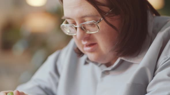 Man with Down Syndrome Doing Paper Crafts with Help of Teacher