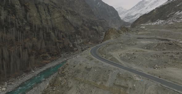 Aerial view of mountain road and two motorcyclists are driving on an empty road. Tranquil Lake Surro