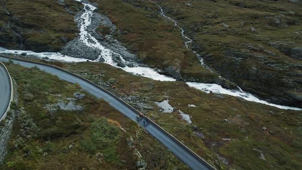 Flying Drone View of Cyclists Riding Up on Road