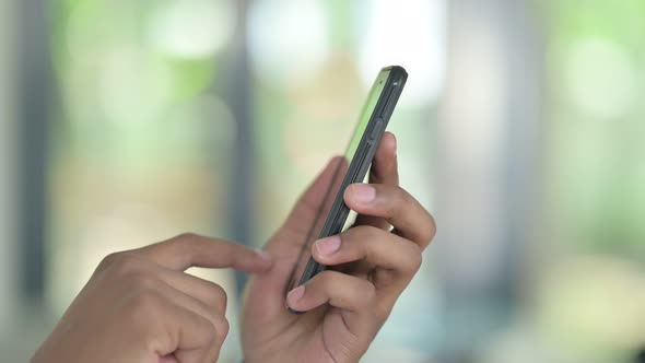 Close Up of Young African Man Using Texting on Smartphone