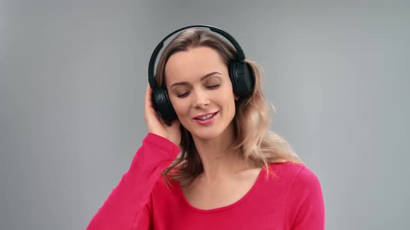 Closeup Face of Enthusiastic Blonde Lady Listening Music in Headphones