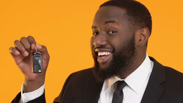 Happy African-American Male Manager Showing Car Keys Into Camera, Rent Service