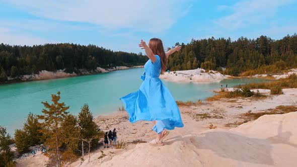 Young Woman in Blue Dress Standing on the Beach and Having a Moment - the Landscape of Blue Lake and