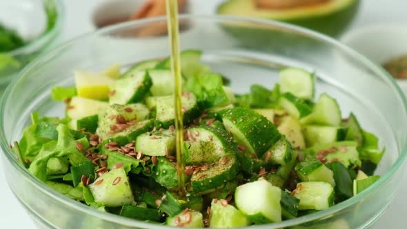 Woman Cooking Salad of Fresh Green Vegetables and Herbs