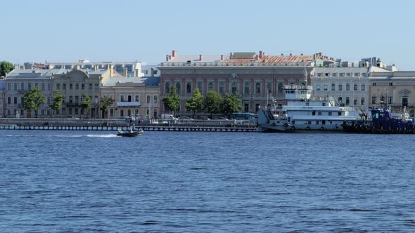 A Boat Floats on the Neva River a Ship and Architecture in the Background