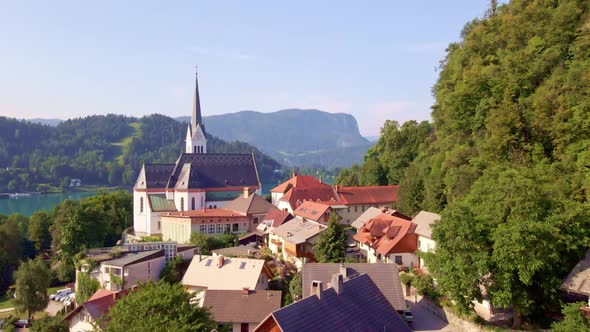 Aerial push-in view over the picture-perfect Alpine town of Bled Slovenia and the beautiful St Marti