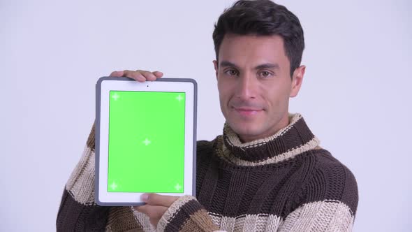 Face of Young Happy Hispanic Man Showing Digital Tablet Ready for Winter