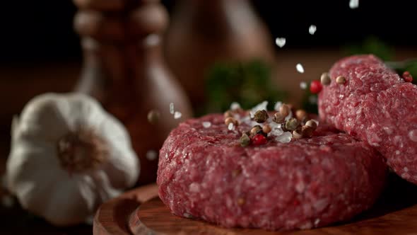 Super Slowmotion Footage of Strewing Salt and Pepper at Fresh Raw Beef Meat Burger 1000Fps