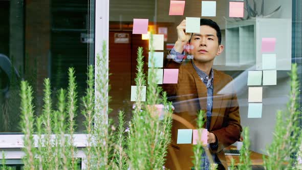 Business executive writing on sticky notes