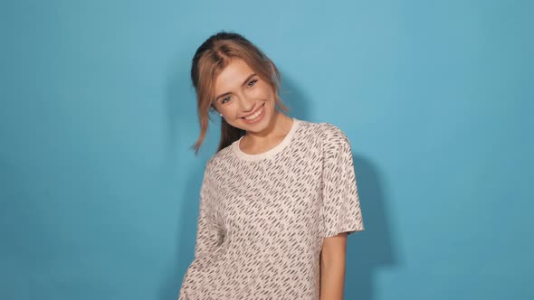 Attractive girl posing in studio near blue wall