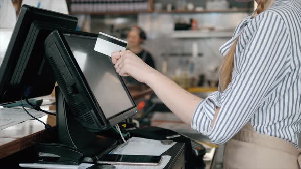 Side View of Young Bartender Using Modern Cash Register at Bar Counter