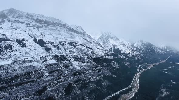 Drone shot of black and white mountain slopes in snowy winter in Kananaskis, Alberta, Canada