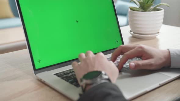 Asian Businessman Wearing Business Suit Typing On Green Screen Computer While Working At Home.