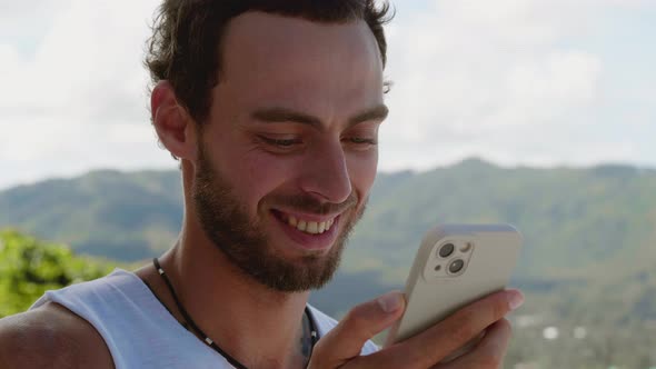 Close Up Portrait of a Connected to Internet Handsome Man Smiling a Cheerful Toothy Smile Using