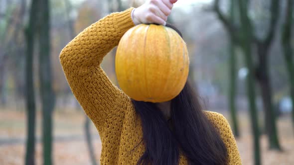 Woman Holding Pumpkins in Hands on an Autumn Sunny Day in the Forest