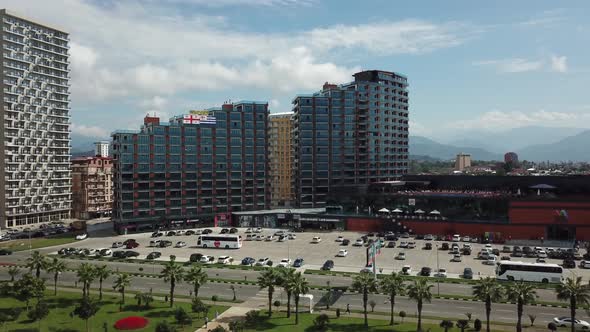 Aerial view on the modern residential complex. Parking with cars at the mall. The camera rises from