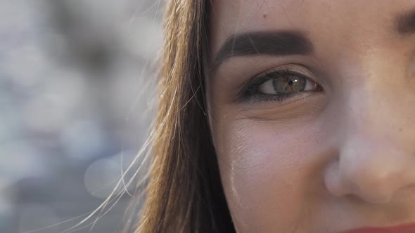 Cropped Shot of an Eye of a Happy Woman on City Streets Background