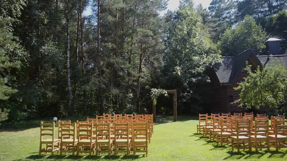 Wedding Reception Area with Arch in Forest on Green Lawn