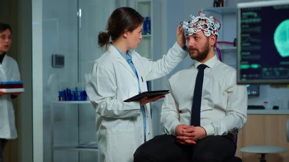 Man Sitting on Neurological Chair with Brainwave Scanning Headset