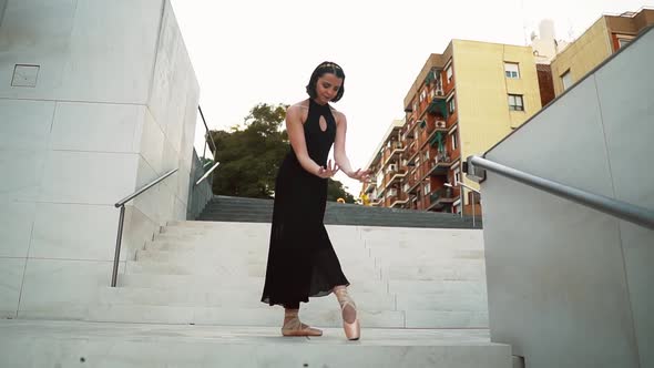 Young Professional Ballerina in Black Dress Is Dancing Outdoors