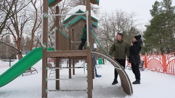 Parents Play with Son on Winter Playground