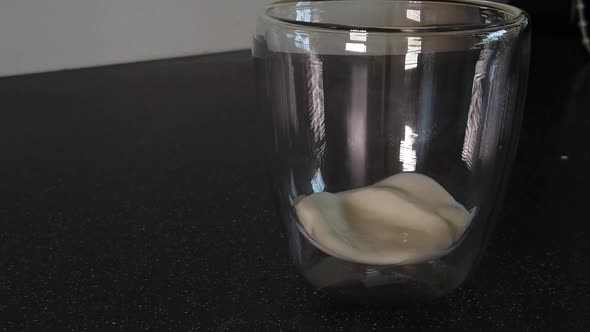 Pouring Yogurt into a glass cup (slowmotion)