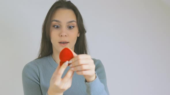 Young Female Student Opening Red Jewelry Box Engagement Ring Showing Emotions